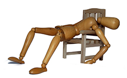 wooden mannequin asleep on chair)